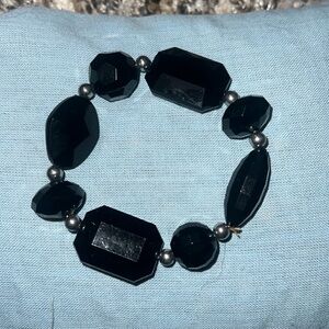 This is a black bracelet with silver beads.